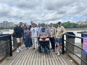 A group of SurvivorsUK and group work facilitators stood by the Thames river on a cultural trip